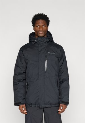 Jachetă waterproof neagră cu glugă, fermoar în față și mansete reglabile. Prezintă accente reflective și un logo pe piept.