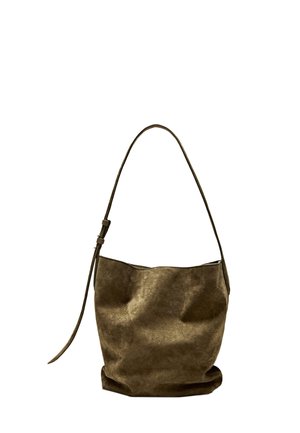 Borsa a tracolla in morbido camoscio marrone con tracolla lunga regolabile e corpo morbido e non strutturato su sfondo bianco.
