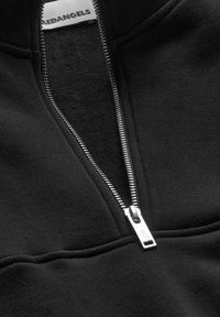 Schwarze Zip-Up-Sweatjacke mit silbernem Reißverschluss, weichem Innenmaterial und gerippten Akzenten am Kragen und Saum. Glatte Stoffoberfläche.