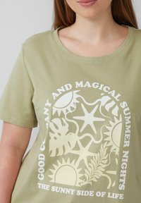 Hellgrünes Baumwoll-T-Shirt mit kurzen Ärmeln und rundem Ausschnitt. Mit einem weißen Grafikdruck von Sonnen, Sternen und tropischen Blättern.