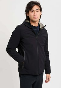 Giacca softshell nera con zip frontale, cappuccio e tasche laterali. Interno con fodera a motivo a contrasto. Vestibilità classica.