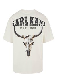 Vit bomull t-shirt med en tryckt tjurhuvuddesign och fet text "KARL KANI EST. 1989" i sliten svart font på baksidan.