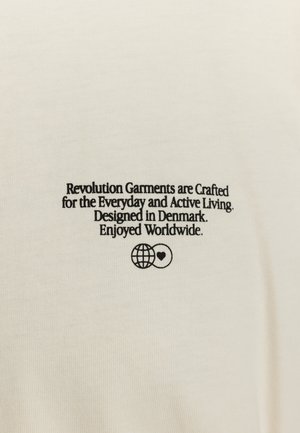 Cream-colored cotton t-shirt featuring black text reading about its design, with a globe and heart graphic. Smooth texture and simple design.