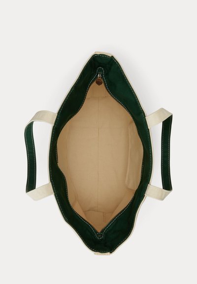 Open lege canvas draagtas met een donkergroene buitenkant, beige binnenkant en dubbele beige handvatten, van bovenaf bekeken, met een ritssluiting.