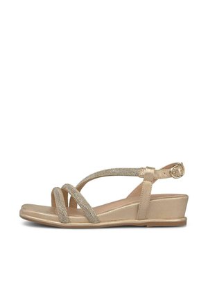 Sandale à talon compensé dorée avec trois fines brides scintillantes sur les orteils et une bride réglable à la cheville avec une fermeture à boucle.