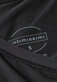 Tela negra con textura suave que presenta una etiqueta que dice "Intimissimi" y tamaño "S" en blanco, con un diseño circular alrededor del texto.