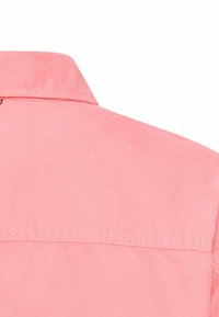 Korallenrosa Hemd aus strukturiertem Stoff, mit Kentkragen und sichtbaren Nähten an der Passe. Die Rückansicht zeigt keine weiteren Details.
