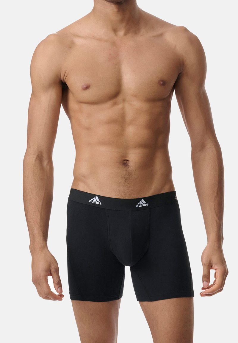 Czarne bokserki wykonane z miękkiej tkaniny, dobrze dopasowane. Posiadają elastyczny pas z logo oraz trzy białe paski z przodu.