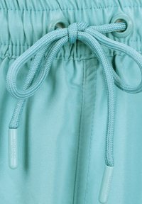 Licht turquoise sportshorts met een textuurband en gevlochten koord met plastic uiteinden. Voorzien van oogjes voor een veilige aanpassing.