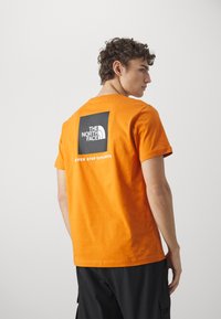 The North Face M SS BOX NSE TEE - T-shirts print - desert rust