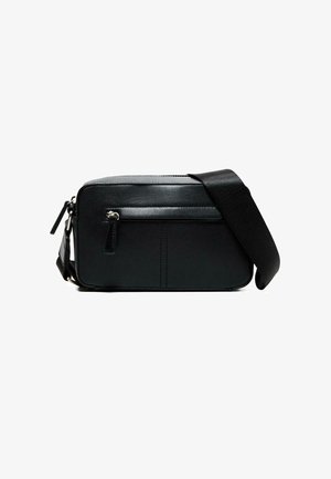 Črna pravokotna torbica čez ramo s sprednjim žepom na zadrgo in širokim nastavljivim ramenskim trakom na belem ozadju.