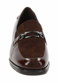Mocasín de cuero marrón y ante con hebilla de metal plateado en la parte superior, punta redondeada y suela negra, mostrado desde el frente.
