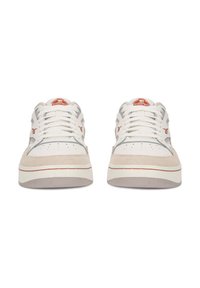 Pár bielych a béžových tenisiek Reebok s oranžovým logom, šnúrky viazané, orientované dopredu na bielom pozadí.