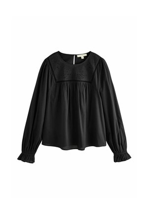 Schwarze Bluse mit langen Ärmeln und rundem Ausschnitt, besticktem Detail auf der Brust, gerafftem Bund und Rüschensäumen. Glatte Stofftextur.