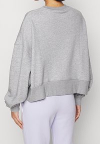 Grå oversized sweatshirt med sänkta axlar och ribbad nederkant. Mjuk bomullsblandning med en slät textur.