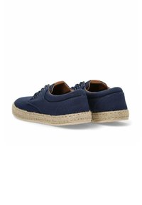 Zapatos espadrilles de lona azul marino con una suela intermedia de yute trenzado y detalles en color marrón. Presenta cordones redondos y un diseño de perfil bajo.