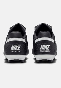 Crampons de football Nike Premier noirs avec une tige en cuir texturé, accents blancs et crampons noirs. Le logo est bien en évidence sur le talon.
