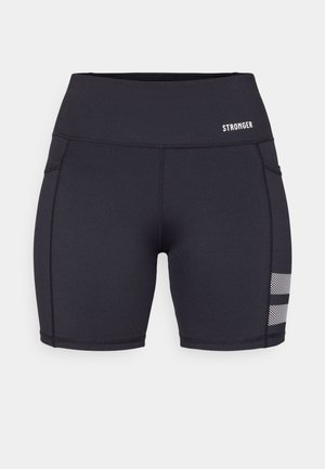 Calções atléticos pretos feitos de tecido elástico. Apresentam costuras lisas, uma cintura alta e detalhes em malha perto da bainha. Logótipo da marca exibido.