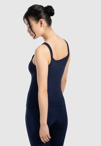 Marineblauwe tanktop met dikke bandjes, aansluitend ontwerp en een soepele textuur. Zichtbaar vanaf de achterkant, gecombineerd met bijpassende legging.