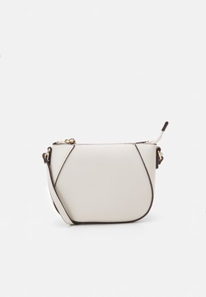 Mała biała skórzana torebka na ramię z czarną lamówką, złotymi elementami i zamkiem błyskawicznym na tle gładkiego białego tła.