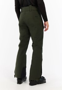 Groene skibroek gemaakt van duurzaam materiaal met verstelbare bandjes, zijritsen en zwarte accenten aan de zoom.