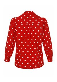 Blouse rouge à manches longues avec des pois blancs, poignets boutonnés et détail plissé au centre du dos.