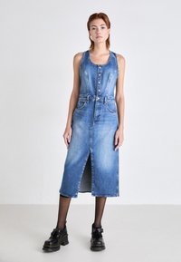 Dżinsowa sukienka midi, jasnoniebieska, bez rękawów, z guzikami z przodu, z paskiem w talii i kieszeniami. Posiada rozcięcie z przodu; gładka tekstura.