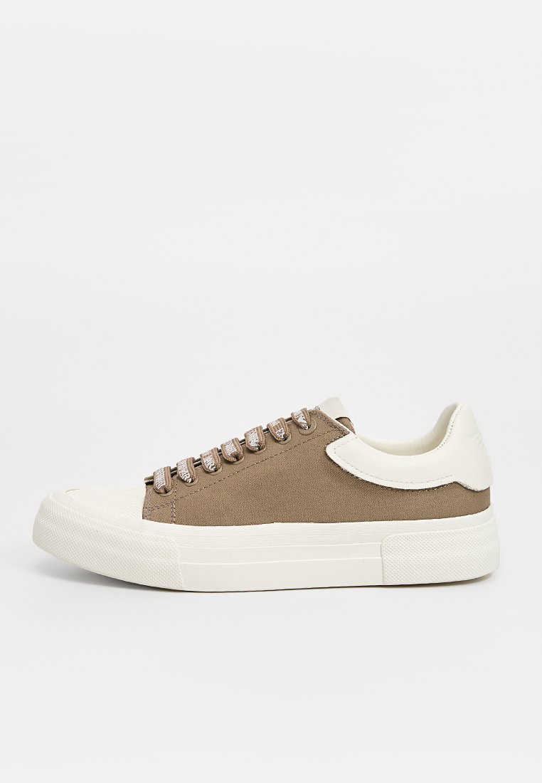 Leichte braune Canvas-Sneaker mit beigen Akzenten, runder Zehenpartie, flacher Gummisohle und metallischen Ösen für die Schnürsenkel.