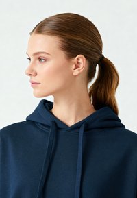 Hanorac cu glugă de culoare albastru marin, cu șnururi, dintr-un material mix de bumbac, cu o croială lejeră, cusături vizibile și glugă căptușită.