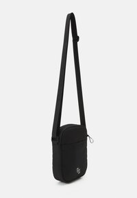 Borsa a tracolla nera realizzata in materiale resistente con un design imbottito, tracolla regolabile e tasca frontale con zip che presenta un dettaglio del logo.