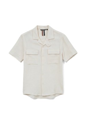 Chemise beige à manches courtes boutonnée, avec deux poches avant à rabat et col camp, posée à plat sur un fond blanc.