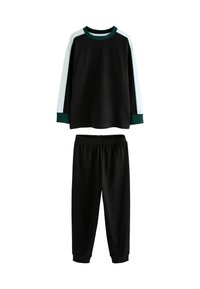 Schwarzes Langarmshirt mit weißen und grünen gestreiften Ärmeln, kombiniert mit schwarzen Jogginghosen mit elastischem Bund.