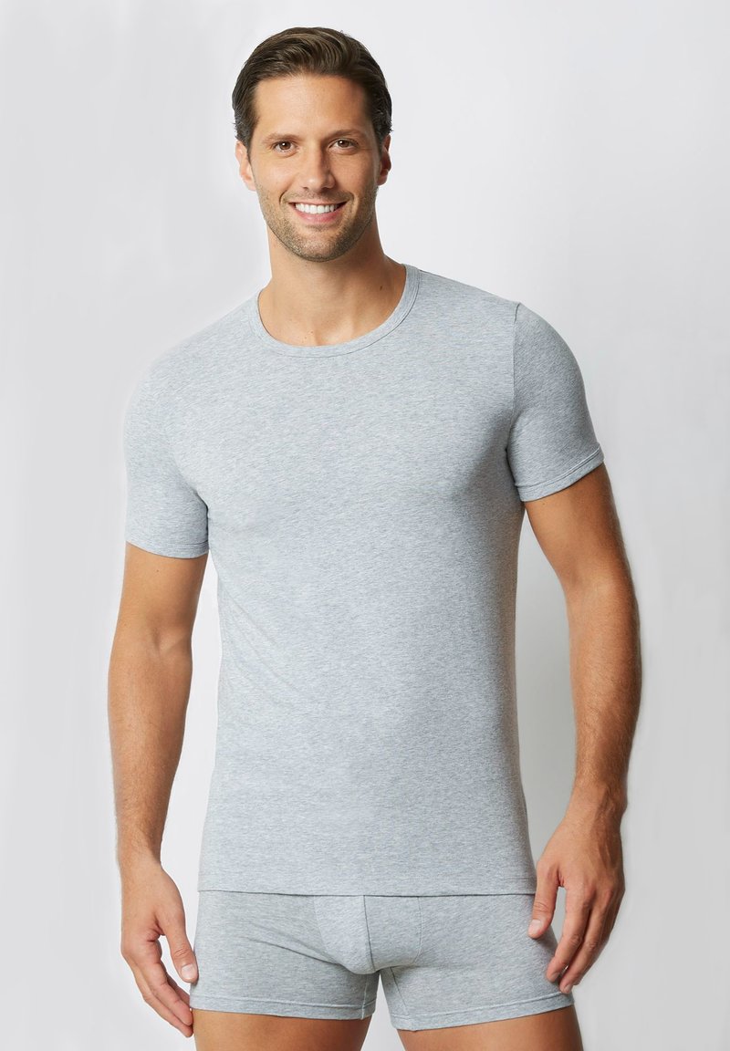 T-shirt grigio a maniche corte e collo tondo, realizzato in tessuto morbido, abbinato a pantaloni corti grigi coordinate. Design semplice senza motivi o dettagli.