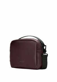 Borsa a tracolla in pelle bordeaux con una texture liscia, tracolla nera regolabile e chiusura con cerniera. Presenta il logo impresso sul davanti.