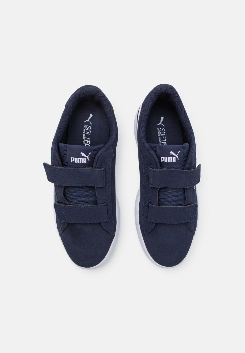 Chaussures en velcro bleu marine avec tige en textile doux, col rembourré et semelle en caoutchouc blanche. Logo visible sur la languette et sur le côté.