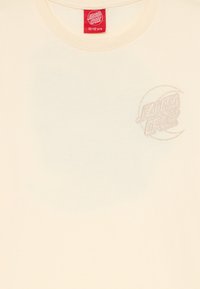 Krämfärgad t-shirt, korta ärmar, rund halsringning. Har en liten, ljus broderad "Santa Cruz"-logga på vänster bröst. Tillverkad av bomull.
