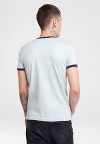 Light blue short-sleeve t-shirt with dark navy trim on the collar and sleeves. Smooth texture, casual design, and simple silhouette.