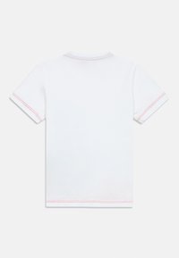 T-shirt branca de algodão com mangas curtas. Apresenta costura vermelha nas bainhas das mangas e na gola. Design simples e clássico, adequado para uso casual.