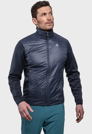 Marineblaues Hybrid-Jackett mit gepolstertem Frontteil, weichen Ärmeln, hohem Kragen und mit Reißverschlüssen versehenen Taschen. Logo in der Mitte der Brust.