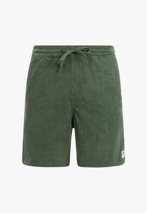 Grüne Cord-Shorts mit Kordelzugbund und Seitentaschen, mit einem kleinen weißen Etikett nahe dem Saum am rechten Bein.