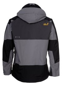 Outdoorová nepromokavá bunda s kapucí v šedé a černé barvě, s logem Jack Wolfskin a štítkem ze strečové tkaniny na zádech.