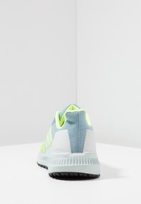 Scarpa sportiva blu e verde neon con tomaia in rete, collo imbottito, suola in gomma e dettagli testurizzati distintivi sul tallone.