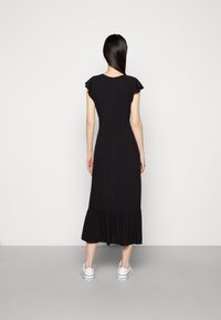 Vestido midi preto com mangas curtas e franzidas, e uma barra em camadas. Feito de um tecido suave, apresenta um corpo ajustado e um fecho de correr nas costas.