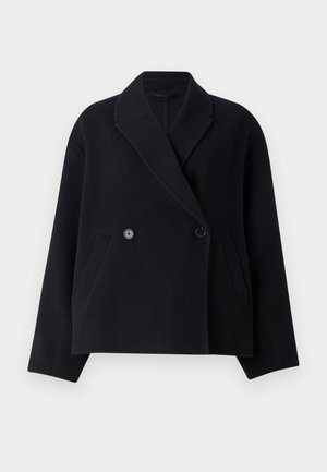 Cappotto in misto lana nero con chiusura doppiopetto, collo a revers, tasche laterali e silhouette ampia. Texture liscia.