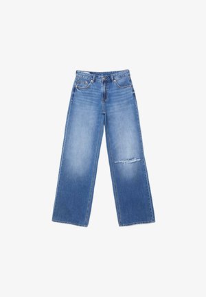 Jean bleu à jambes larges avec taille haute, poches avant, fermeture par bouton et fermeture éclair, et une déchirure usée sur la cuisse droite.