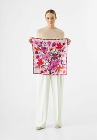 Carré en soie avec un motif floral dans des teintes de rose, rouge et violet, bordé d'une finition en zigzag rouge foncé.