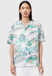Camisa de manga corta hecha de un tejido ligero, con un colorido estampado tropical que incluye palmeras y flores, botones y un bolsillo en el pecho.