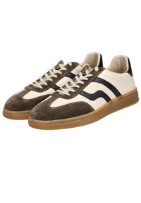 Pruun nahk- ja beežist nahk sneakers mustade triipudega, tekstureeritud kummist tallaga ja beežide paeltega. Madalma design paksema kraega.