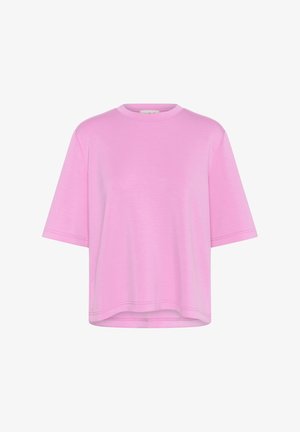 Różowa koszulka z krótkim rękawem w luźnym fasonie, wykonana z miękkiego materiału, z okrągłym dekoltem i prostym wykończeniem. Minimalne detale szewne.