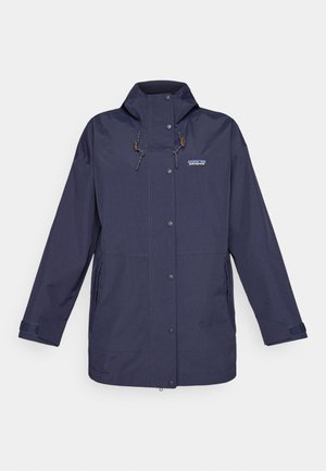 Giacca impermeabile blu navy con zip e chiusura a pressione, cappuccio regolabile e tasche laterali. Presenta asole marroni e un logo sul petto.